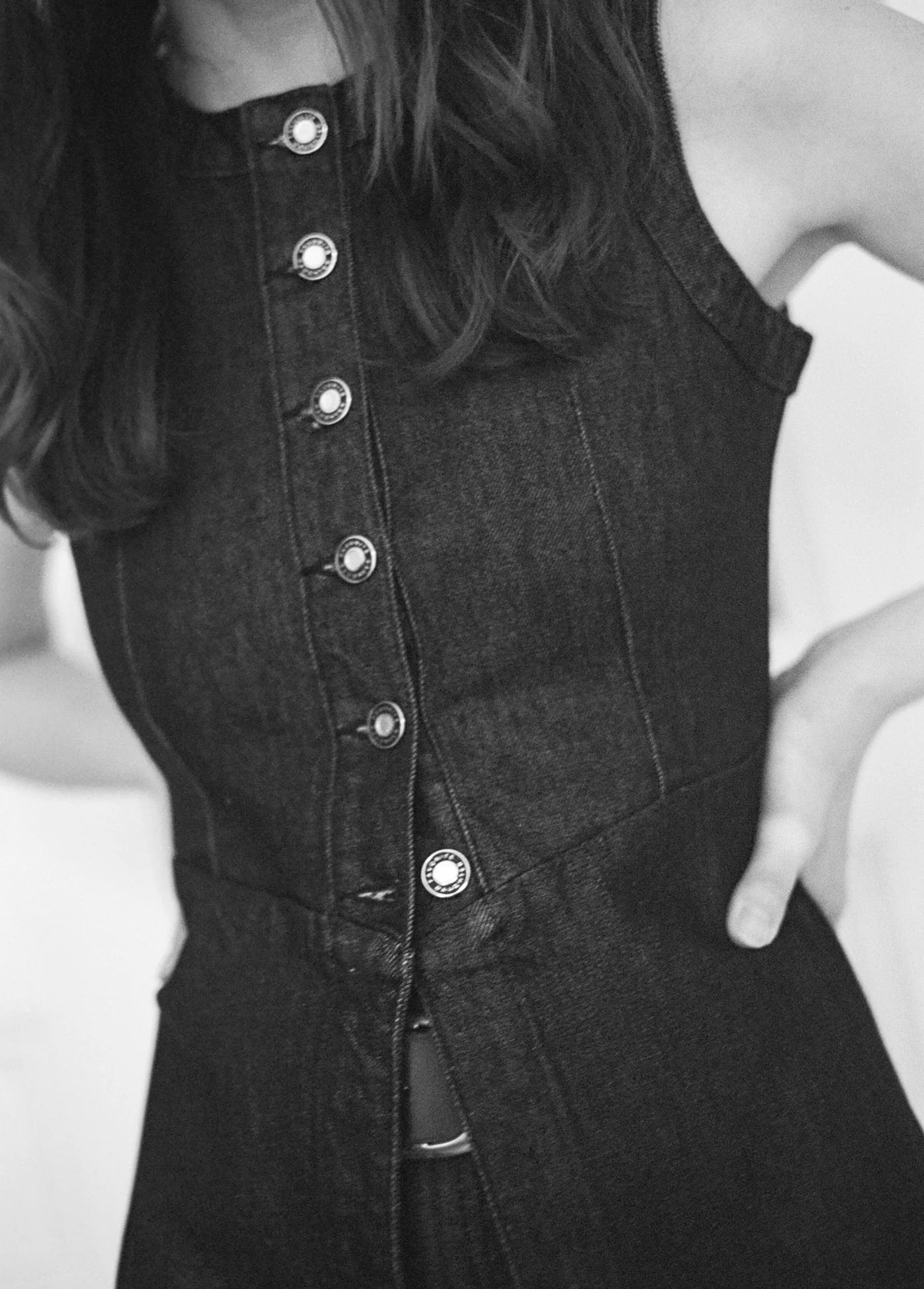 Black and white close-up of a person wearing a button-up dress.