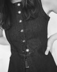 Black and white close-up of a person wearing a button-up dress.