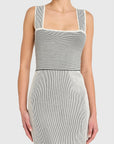 Woman wearing a sleeveless, striped dress on a white background