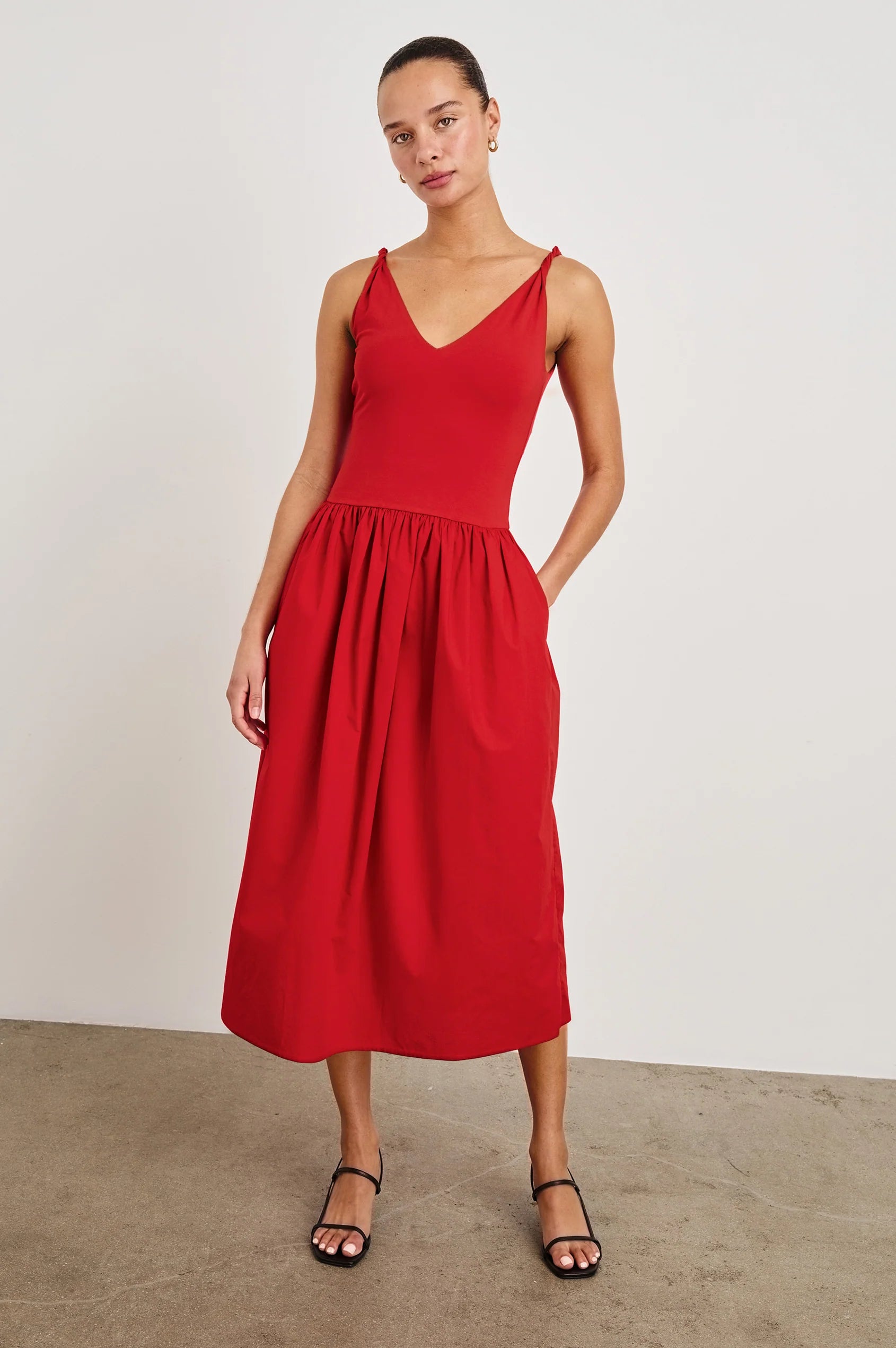 Woman wearing a red dress against a plain background front view