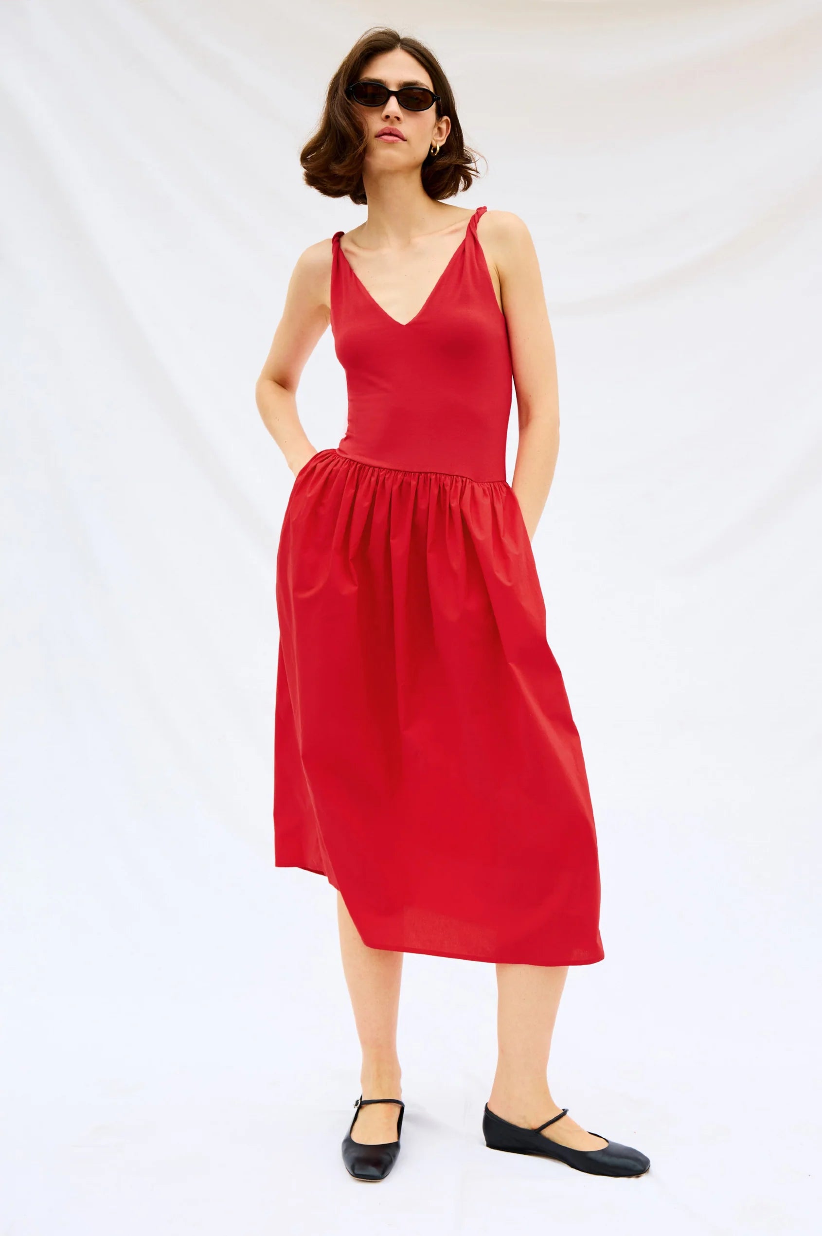 Woman wearing a red dress on a white background front view