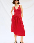Woman wearing a red dress on a white background front view