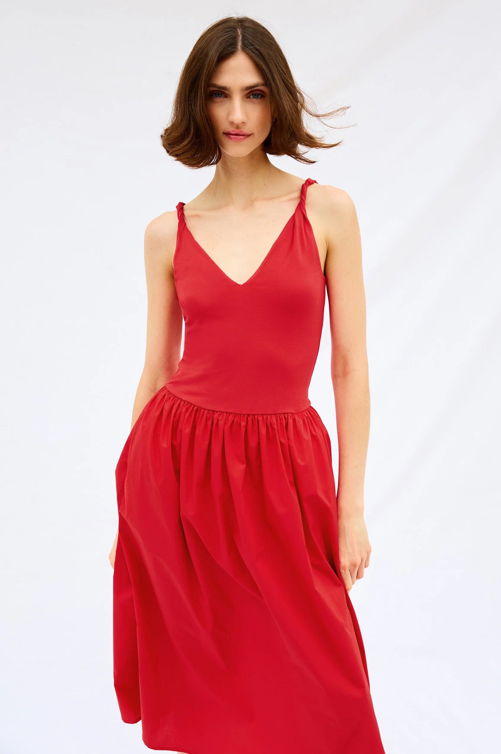 Woman wearing a red dress on a white background front view