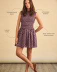 Woman wearing a patterned dress with text labels on a beige background