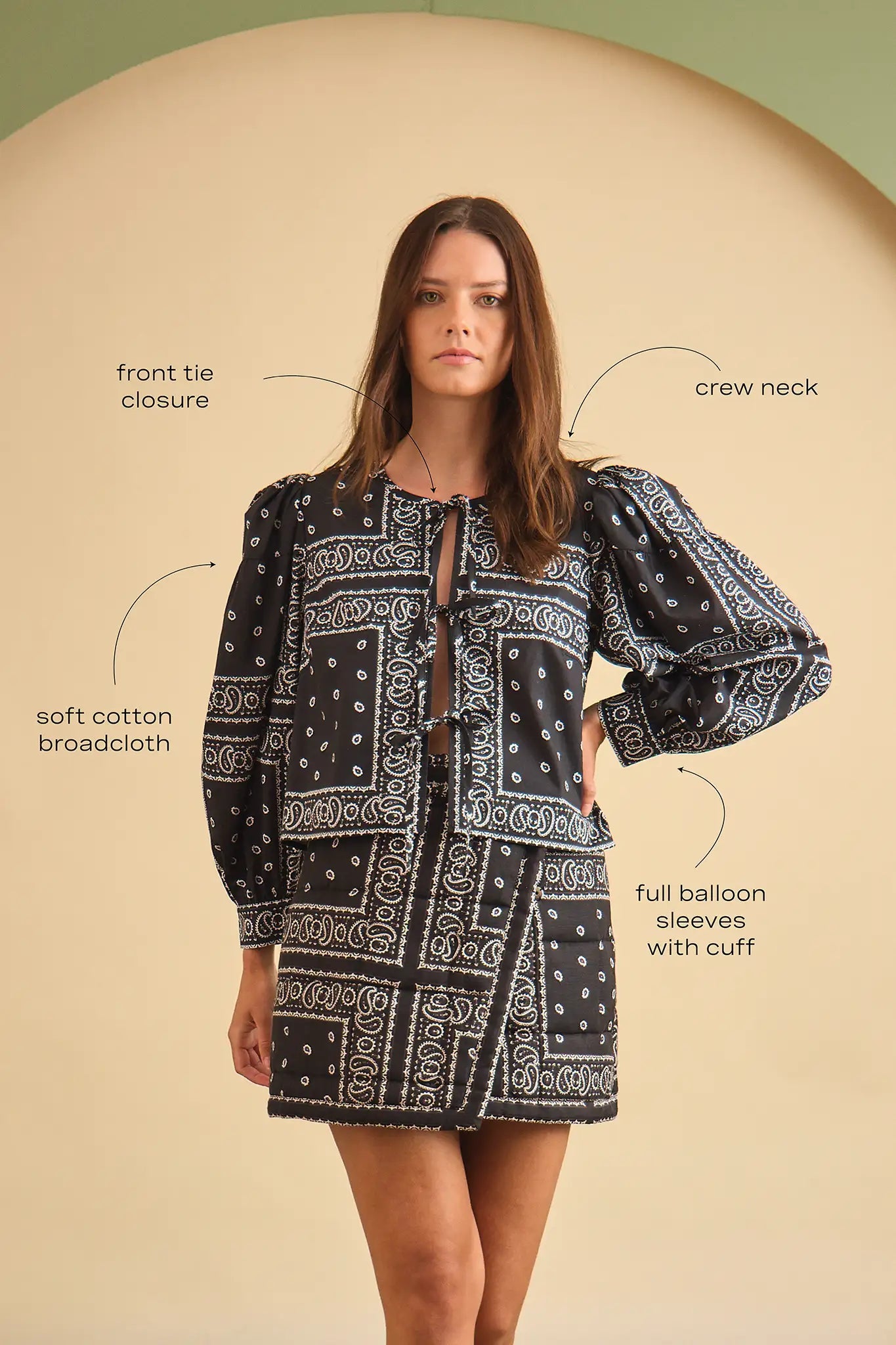 Woman wearing a black and white patterned outfit with text labels on a beige background