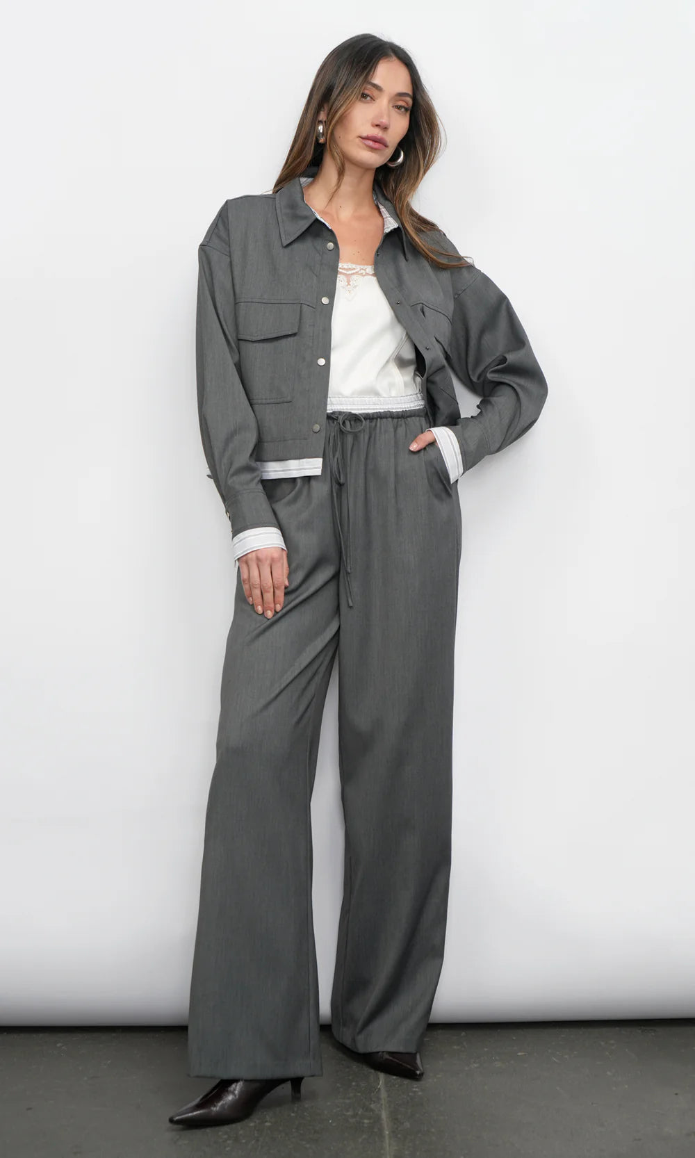 Woman wearing a gray outfit with a white background