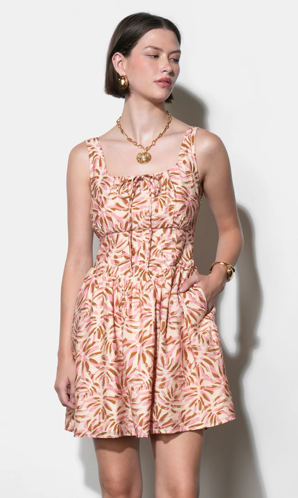 Woman wearing a pink floral dress against a white background