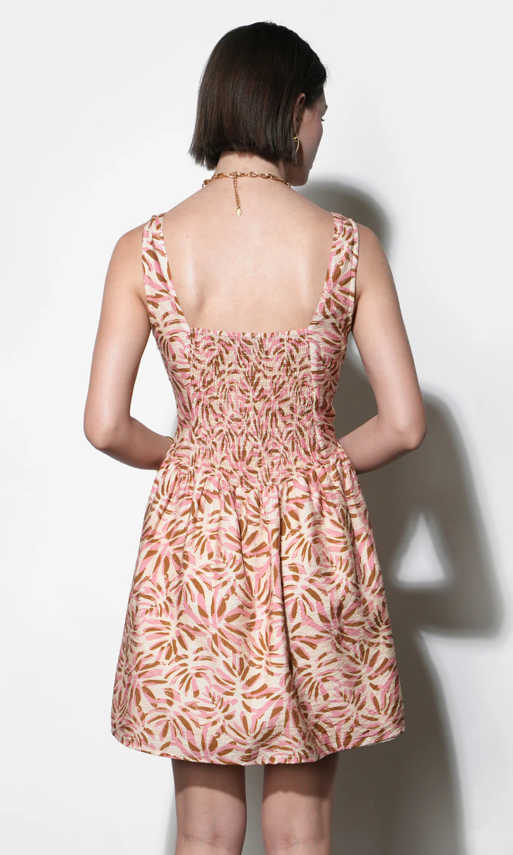 Woman wearing a patterned dress against a white background