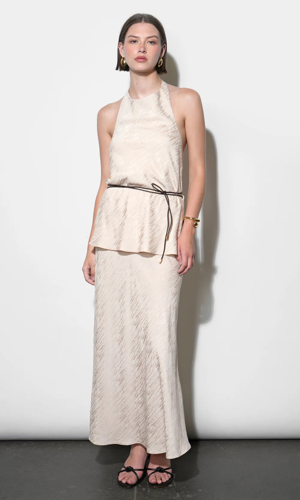 Woman wearing a white lace dress against a white background