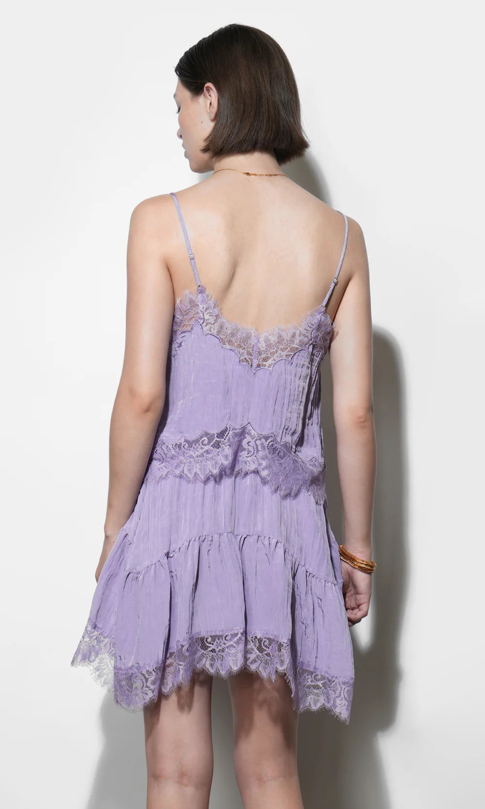 Woman wearing a purple lace set against a white background