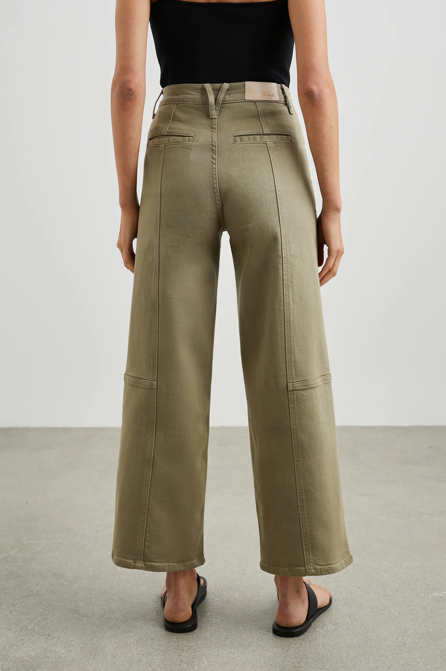 Person wearing olive green wide-leg pants on a plain background