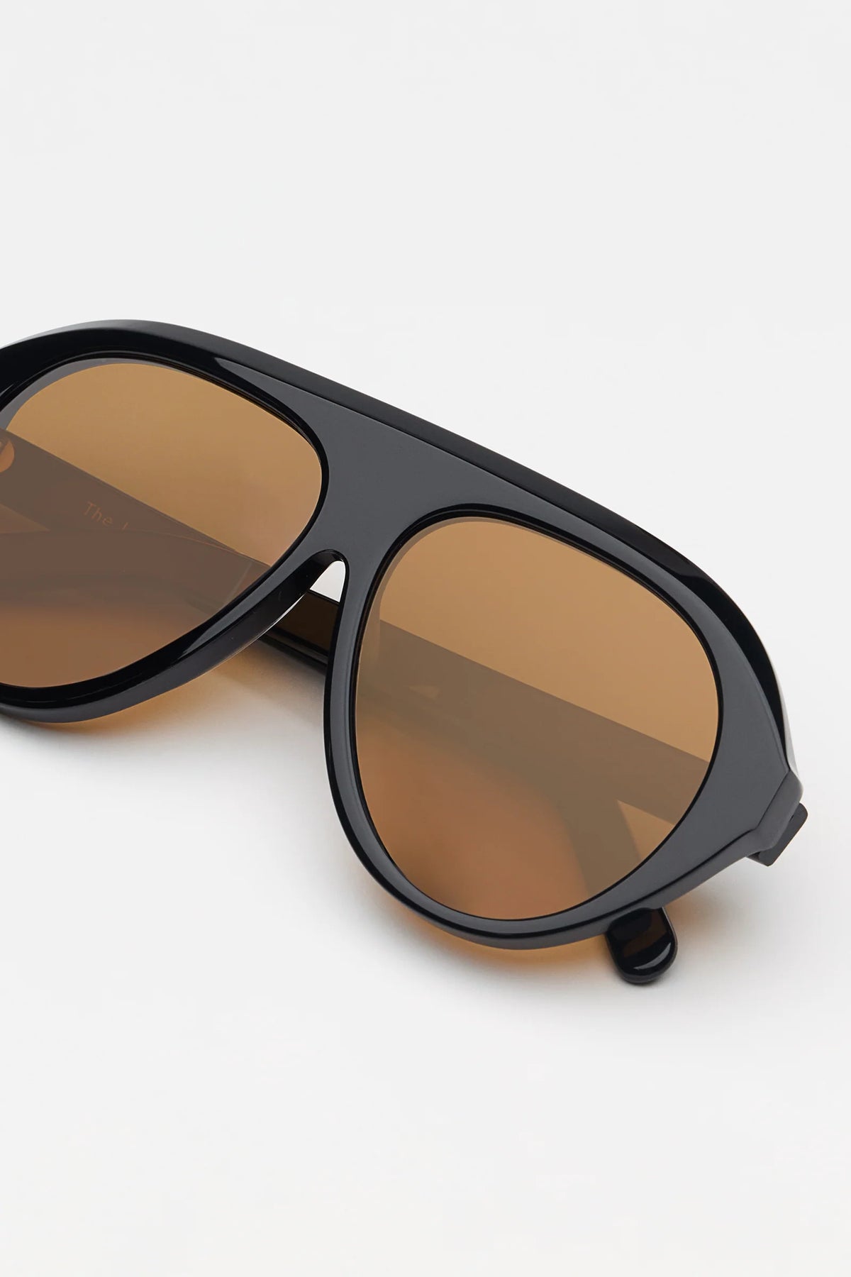 Sunglasses with brown lenses and black frame on a white background