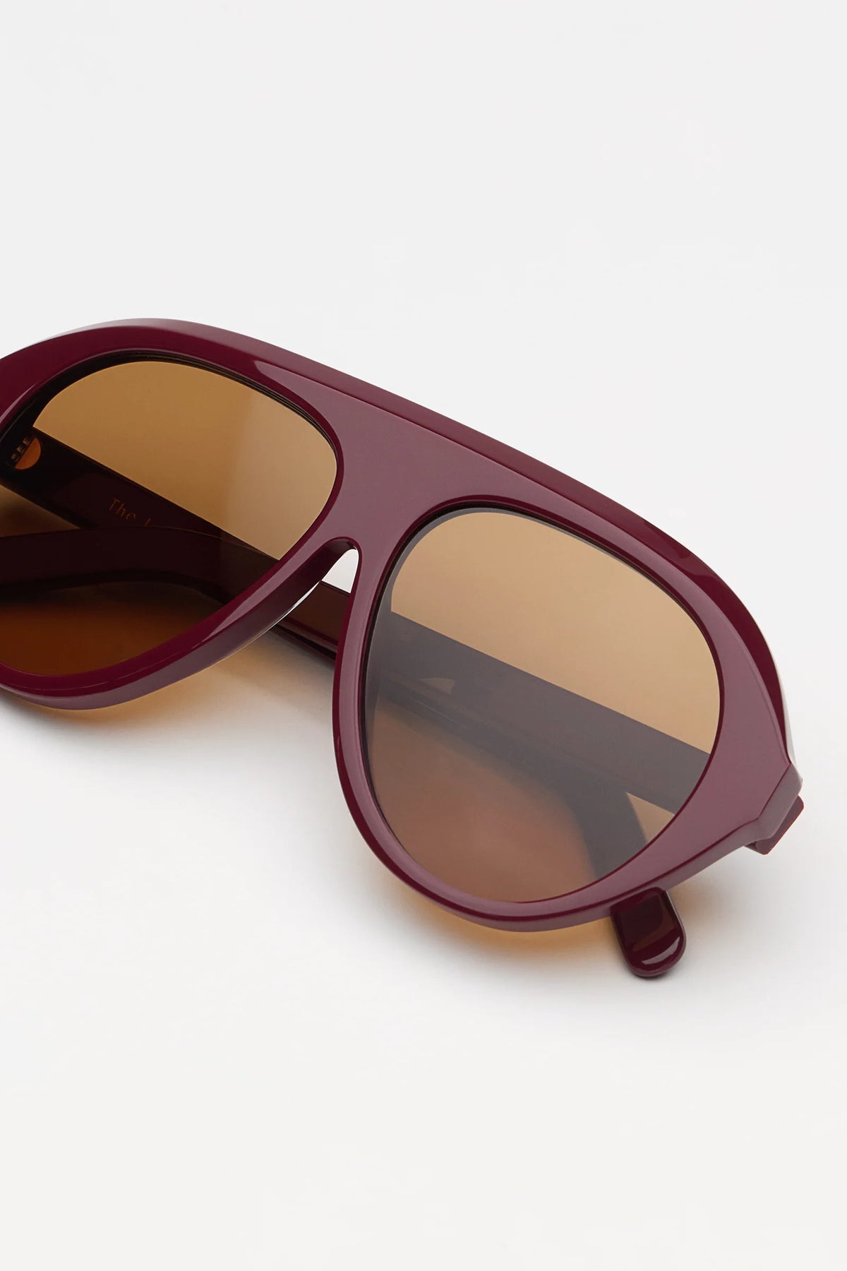garnet oversized sunglasses with amber lenses on a white background 