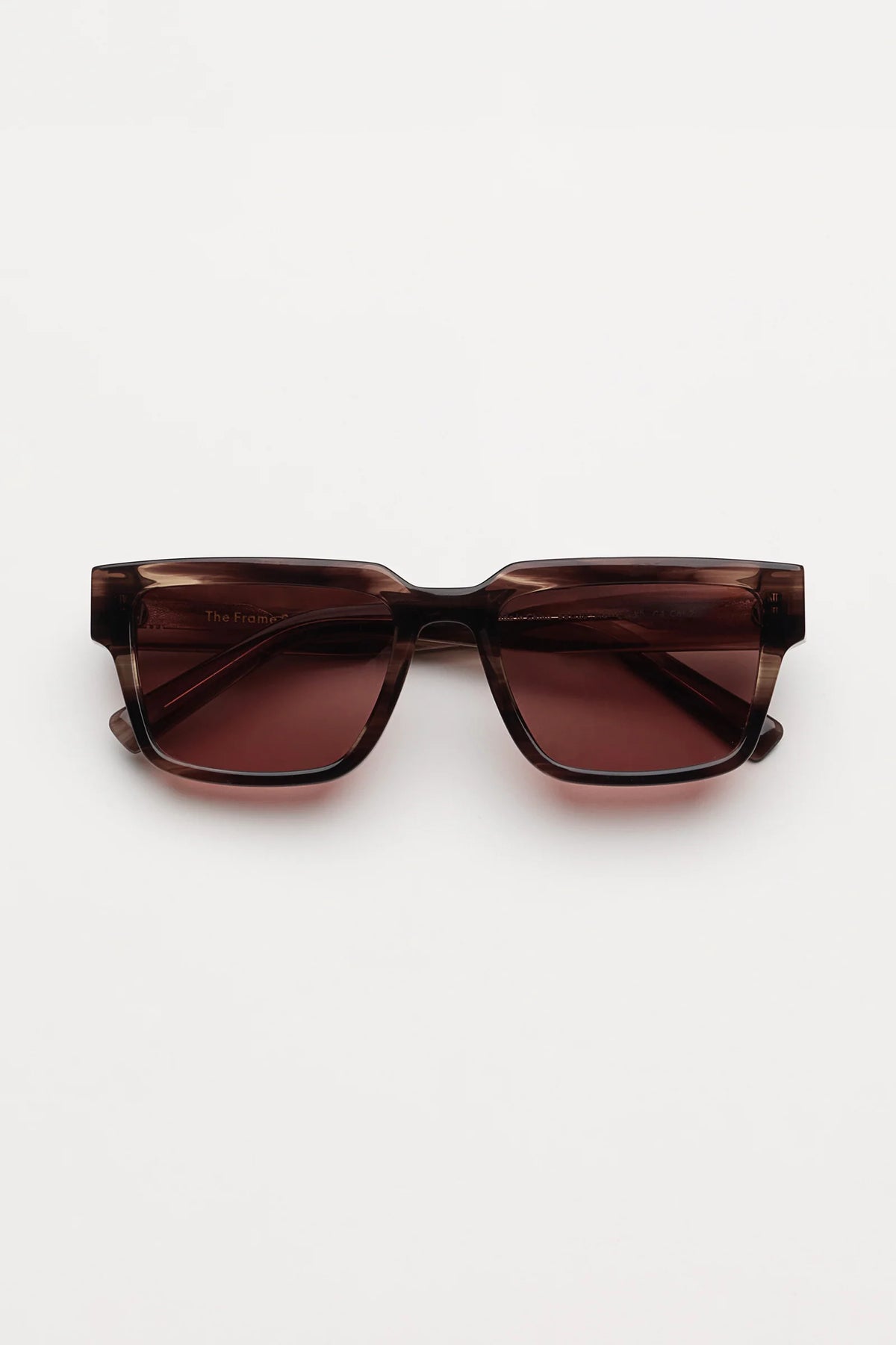 Square sunglasses with a translucent redish brown tortoiseshell frame and light red lenses, shown against a plain light gray background.