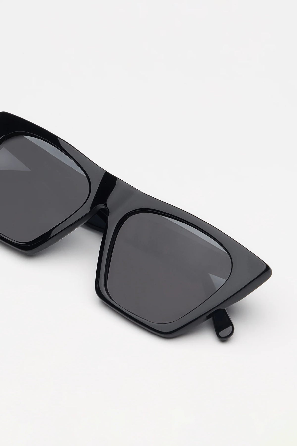 Black sunglasses with dark lenses on a white background