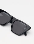 Black sunglasses with dark lenses on a white background