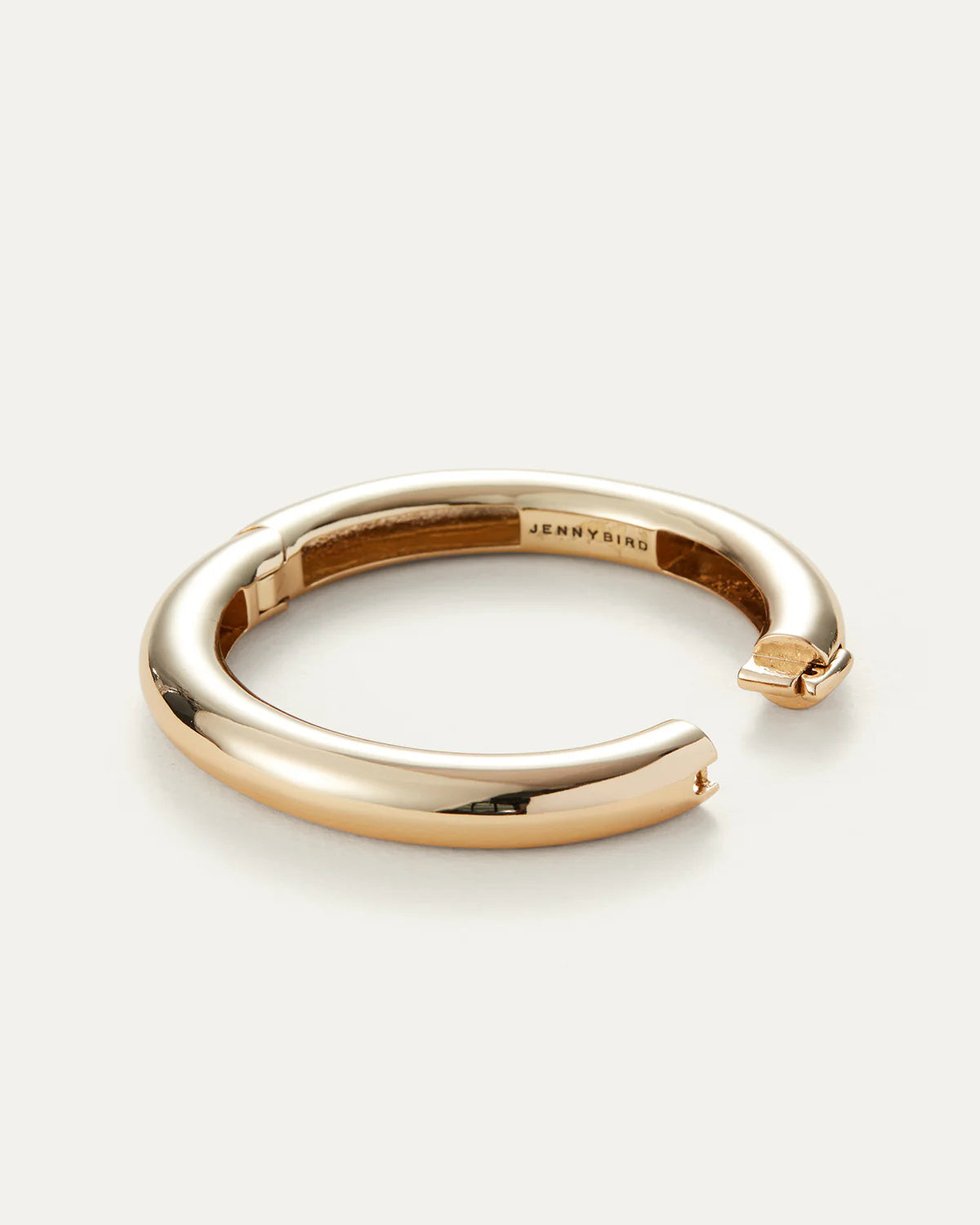 Gold ring with 'Jenny Bird' engraving on a white background