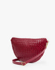 A woven leather crescent-shaped shoulder bag in deep burgundy red, featuring a matching leather strap with gold-tone hardware, set against a plain white background.