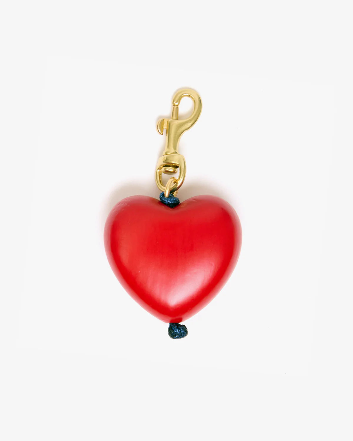 Red heart-shaped charm with gold clasp on a white background