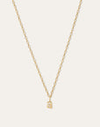 A delicate gold chain necklace with a small lowercase letter 'a' pendant, displayed against a solid off-white background.
