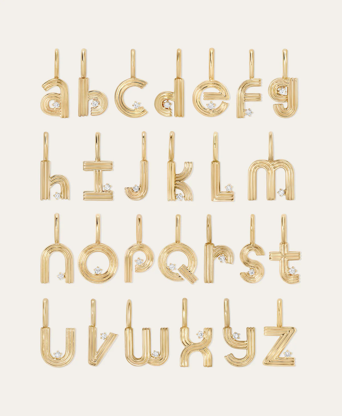 Gold alphabet initial earrings arranged in a grid on a light cream background, each letter featuring a small diamond