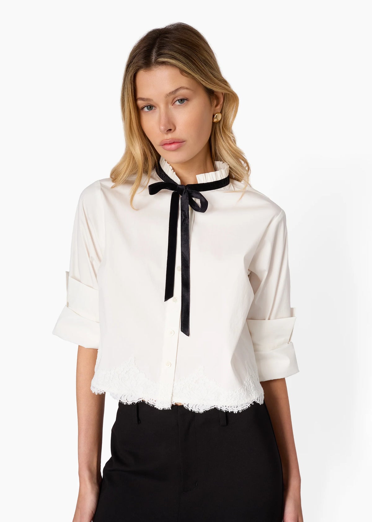 Woman wearing a white blouse with a black bow tie on a white background