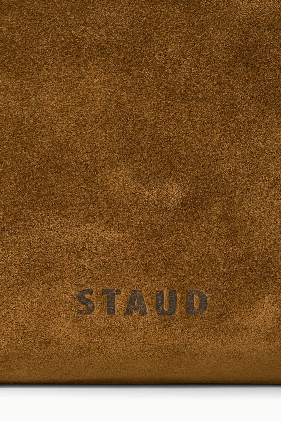 Close-up of Cy Convertible Bag Cigar with STAUD embossed in dark lettering near the bottom.