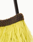 Close-up of a bright yellow ostrich feather fringe bag with a dark brown beaded trim and a black strap, set against a plain white background.