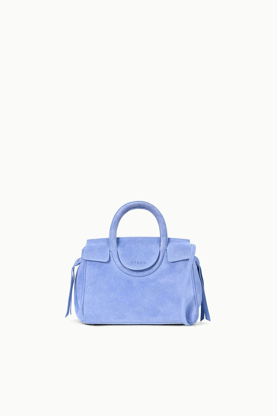 A light blue suede handbag with a top handle, flap closure, and tassel details, centered on a plain white background.