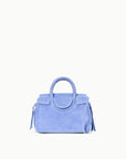 A light blue suede handbag with a top handle, flap closure, and tassel details, centered on a plain white background.