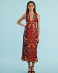 model wearing a print midi dress with black heels on a blue back ground 