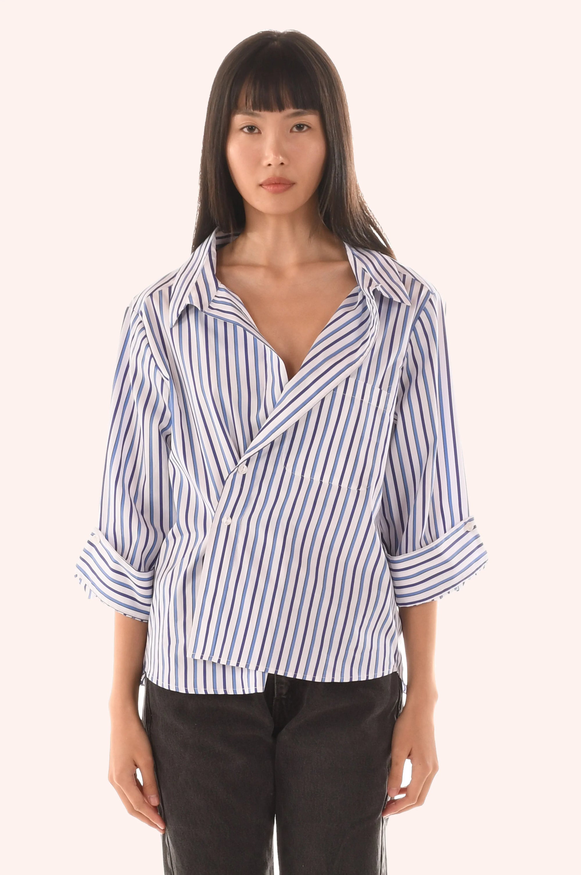 Woman wearing a blue and white striped shirt on a white background  front view