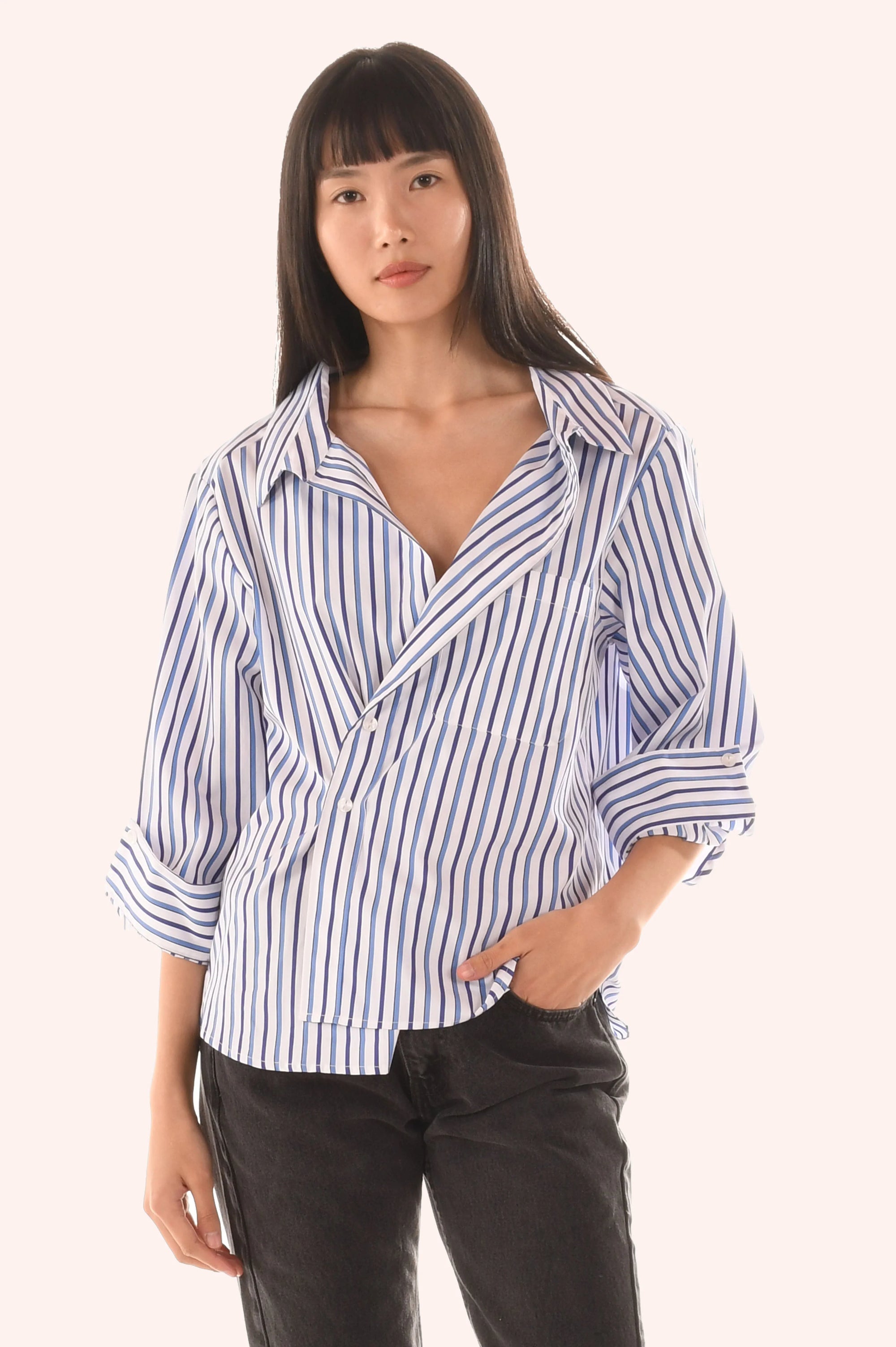 Woman wearing a blue and white striped shirt against a white background front view