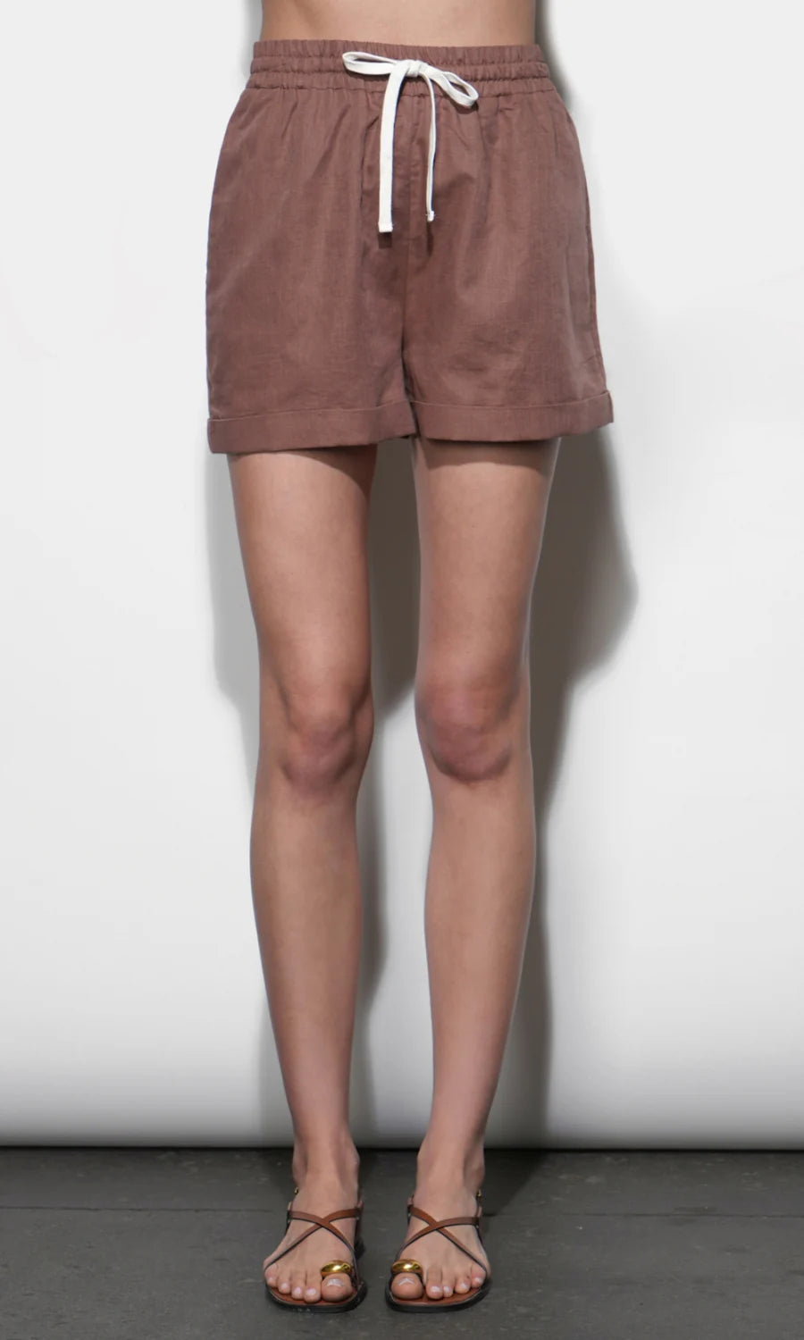 Brown shorts worn by a person against a white background