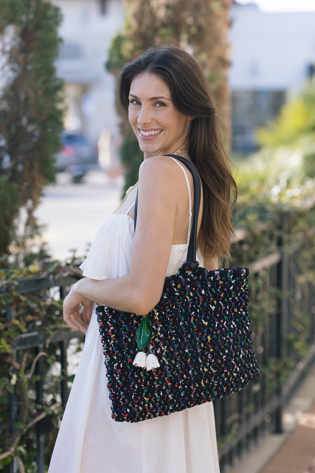 Woman holding a colorful tote bag outdoors