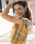 Woman wearing a yellow plaid outfit with a blurred background