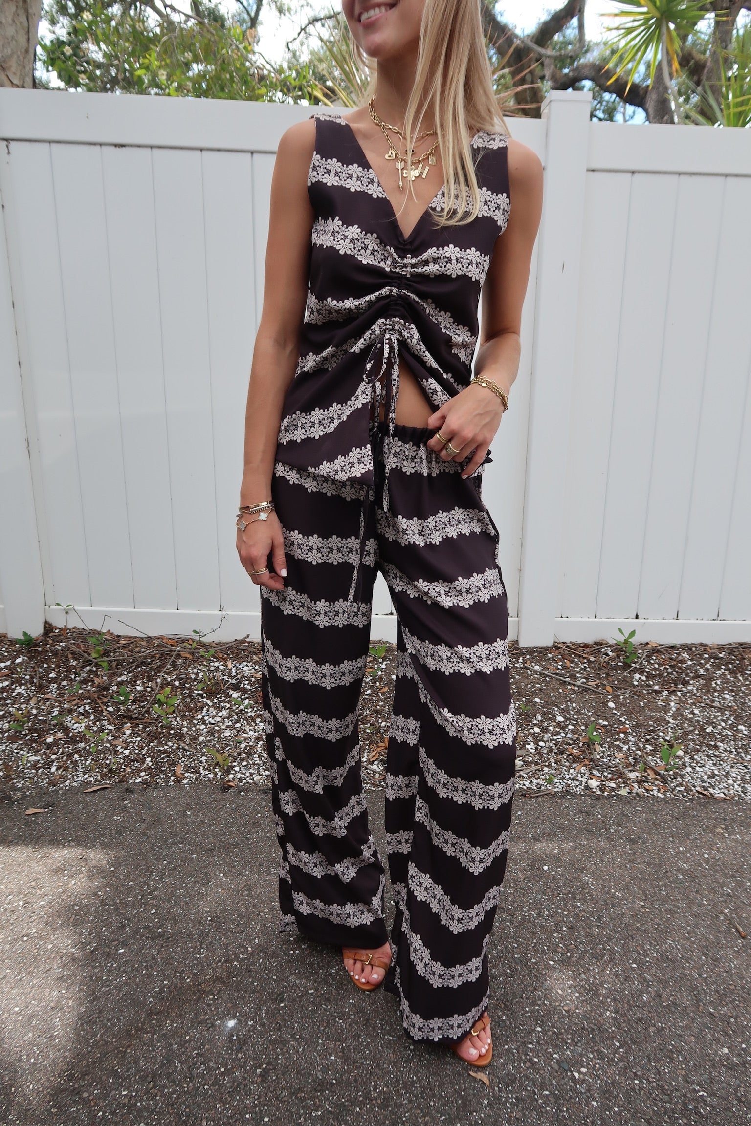 Woman wearing a black and white striped set standing outdoors.