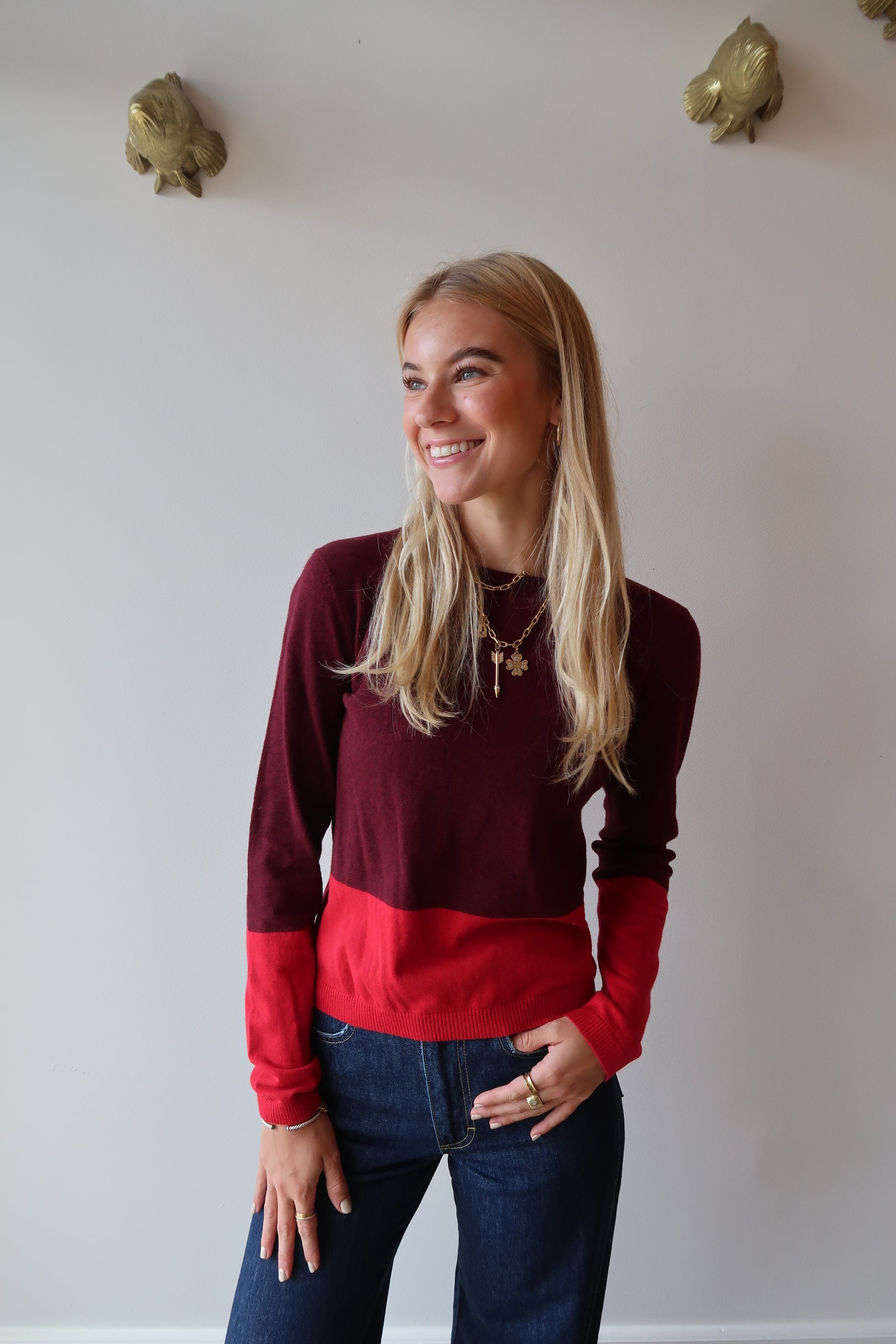 Woman wearing a red and burgundy sweater with a white background