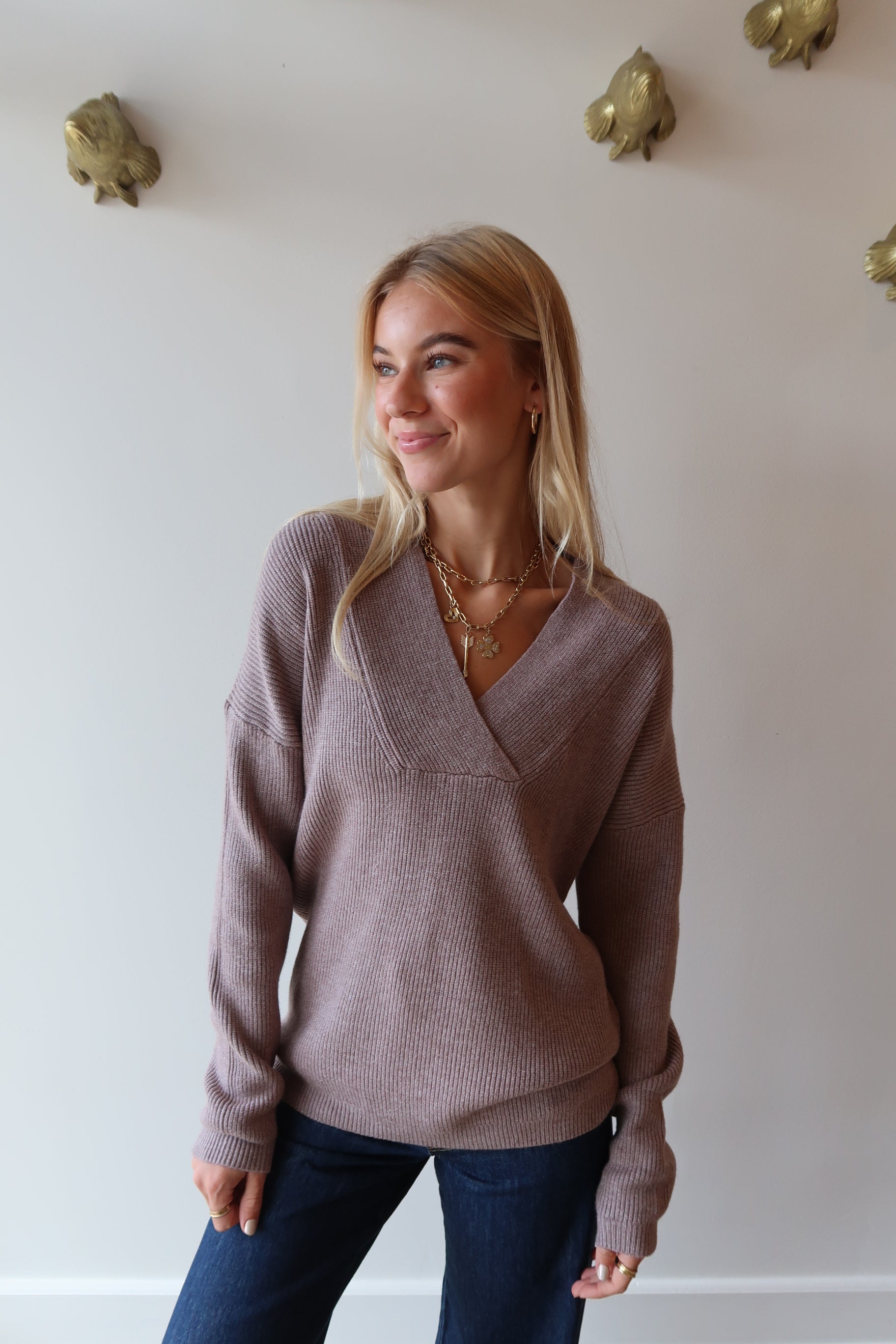 Woman wearing a brown sweater and blue jeans 