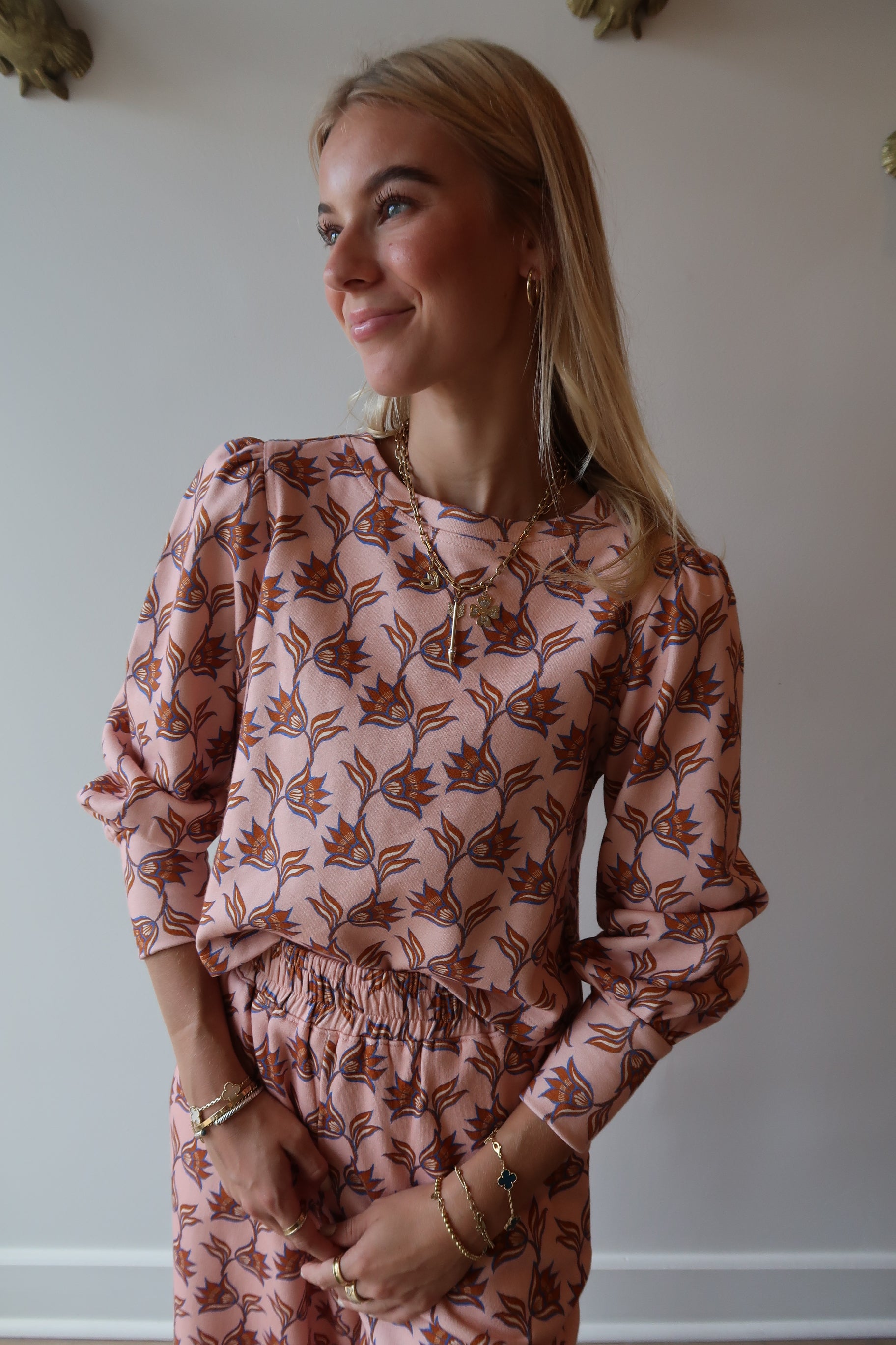 Woman wearing a floral sweatshirt with a neutral background