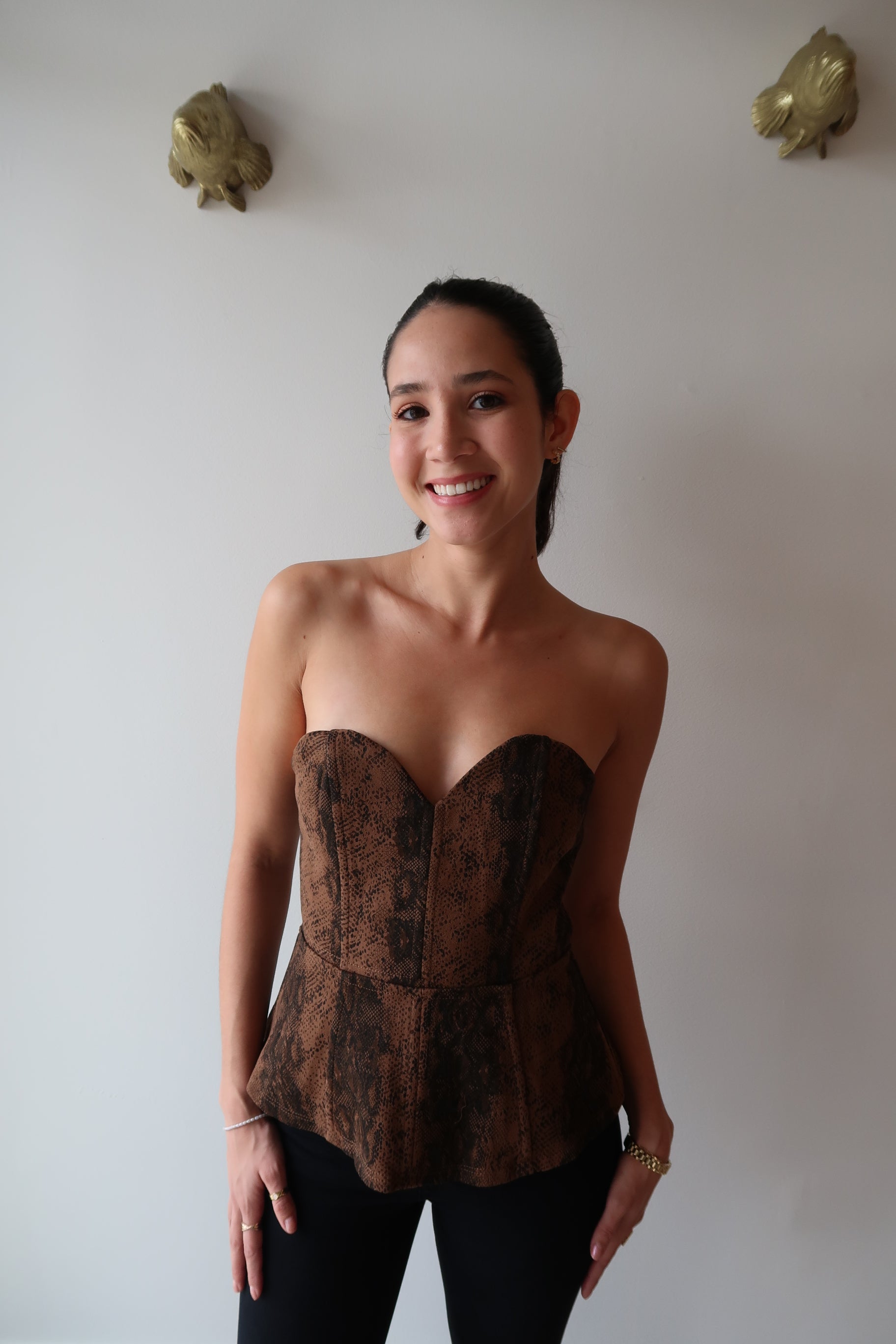 Person wearing a textured top and black pants on a plain background