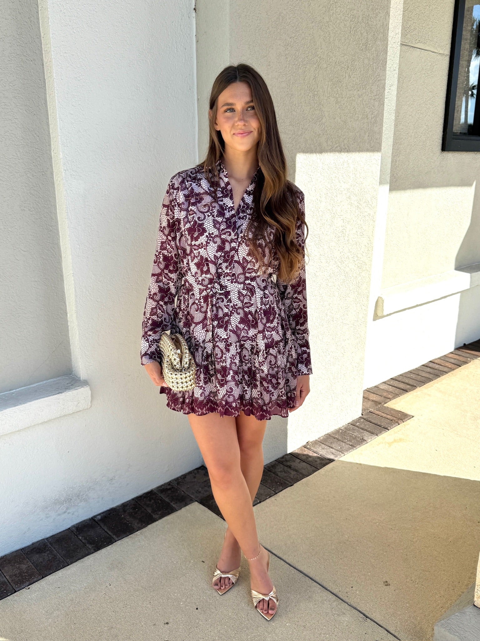 Woman in a floral dress standing outside a building
