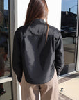 Person wearing Renata Cropped Button Down standing in front of a glass door. back view