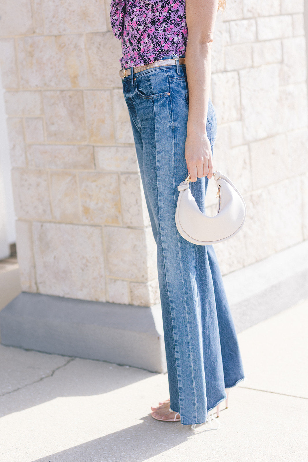 The Tux Sidestepper Sneak Fray close up side view, model holding Avery Leather Crossbody Bag