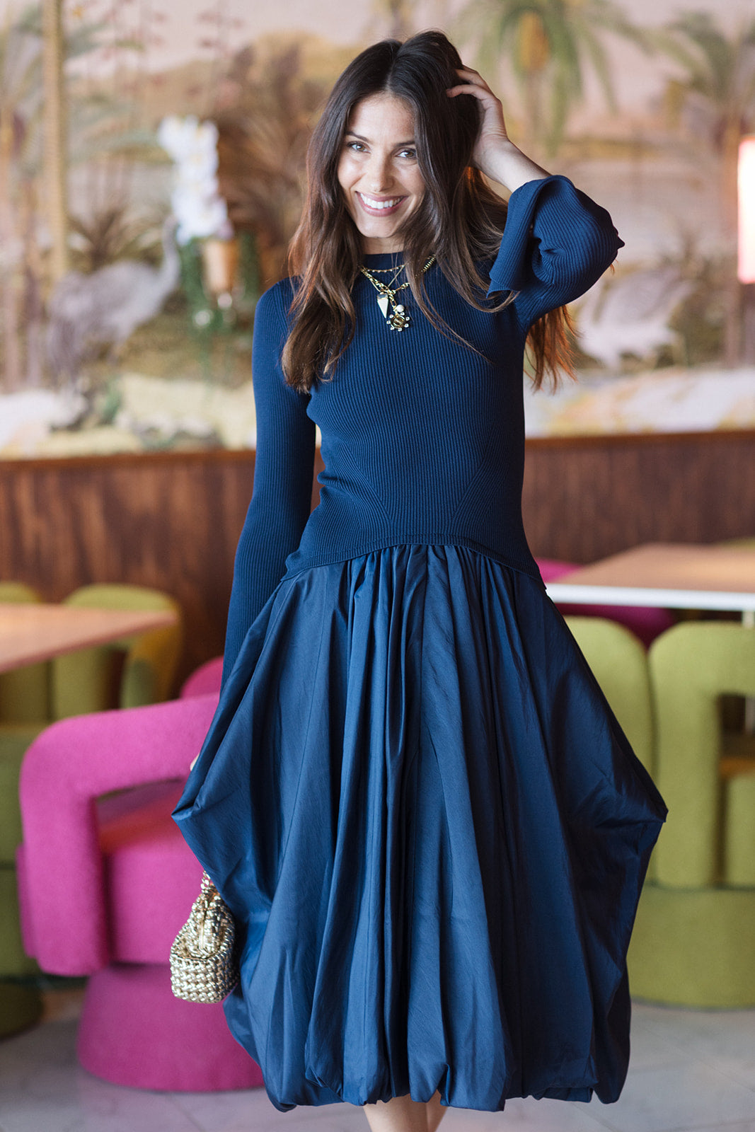 Model wearing a blue dress with a colorful background