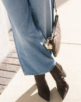 Close-up of a person wearing blue jeans and brown boots