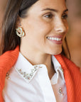 pretzel clip on earrings on a model with a white shirt and orange sweater