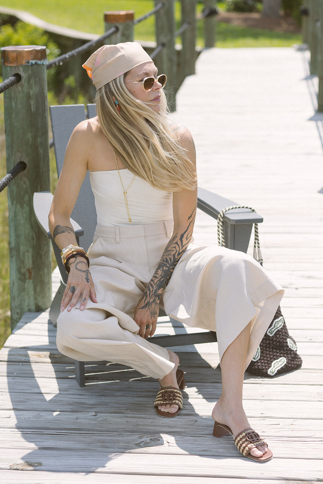 Woman in a white outfit sitting on a wooden deck wearing Sydney Rope Woven Block Heel