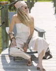 Woman in a white outfit sitting on a wooden deck wearing Sydney Rope Woven Block Heel