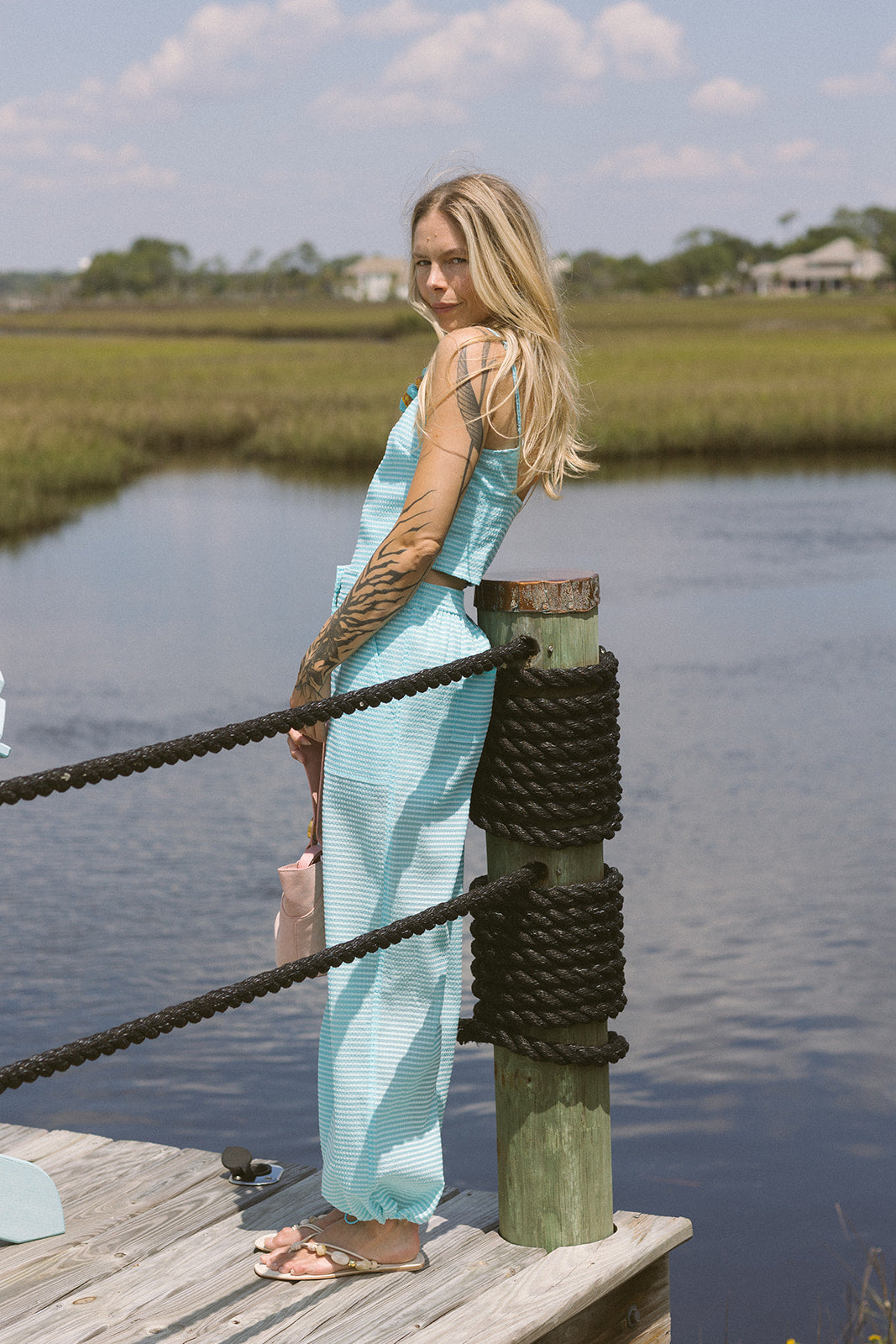 Woman in a light blue matching set by a body of water